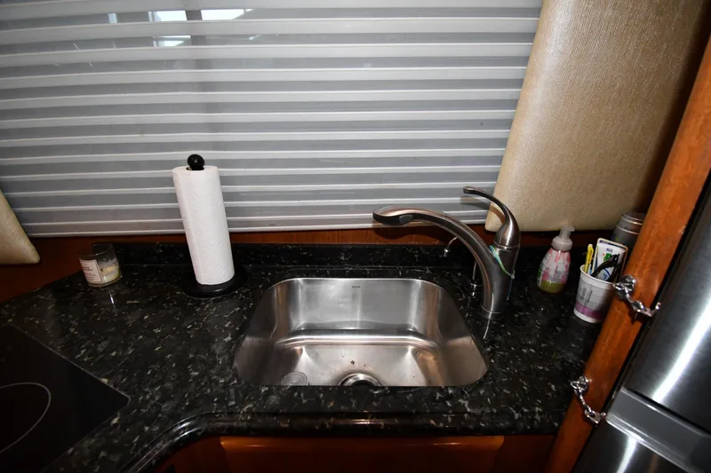 Slide: The Image of Kitchen sink area in a 1996 Viking 50 Convertible yacht with granite countertop. - 55