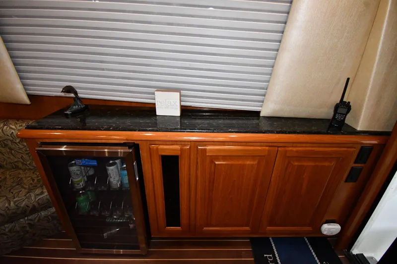 Slide: The Image of 1996 Viking 50 Convertible yacht interior with minibar, wooden cabinetry, and decorative accents. - 58