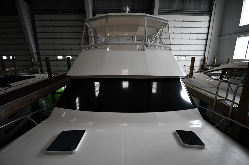 Slide: The Image of 1996 Viking 50 Convertible yacht in indoor storage, showcasing sleek design and spacious deck. - 6