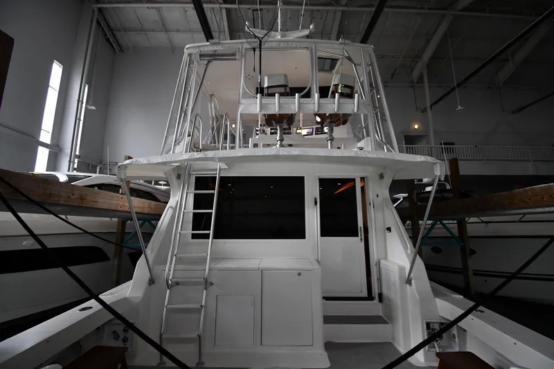 Slide: The Image of 1996 Viking 50 Convertible yacht in indoor storage, rear view showing ladder and upper deck. - 7