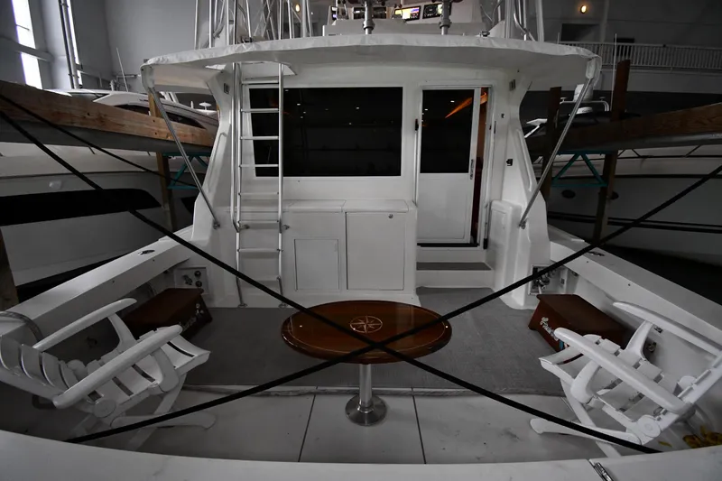 Slide: The Image of 1996 Viking 50 Convertible yacht interior with seating and table in a marina. - 8
