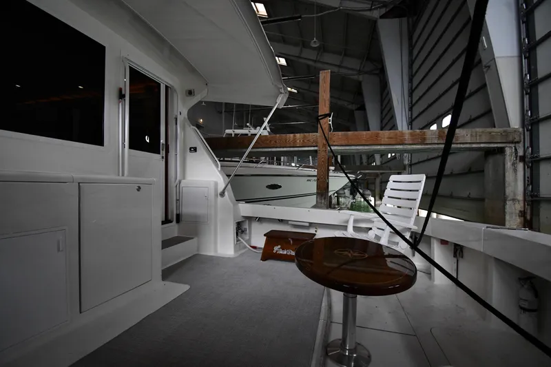 Slide: The Image of 1996 Viking 50 Convertible yacht interior with seating and table in a marina setting. - 9