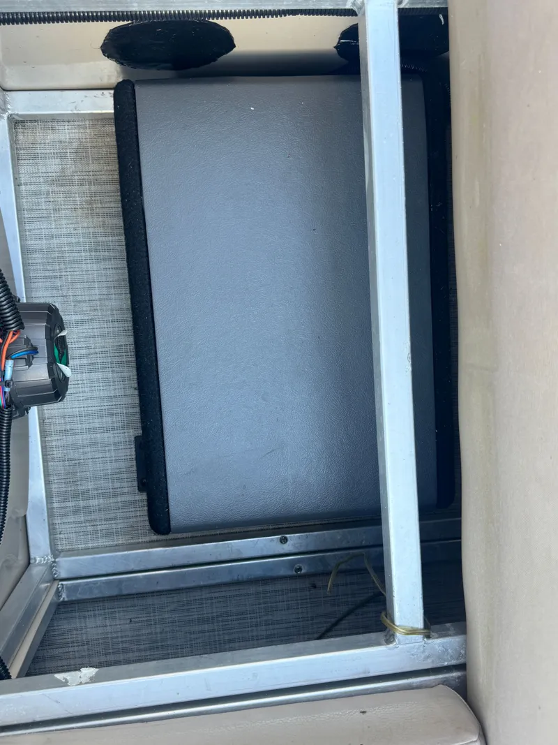 Slide: The Image of Storage compartment of a 2017 Avalon LSZ rf 2285 boat, featuring wiring and a gray panel. - 24