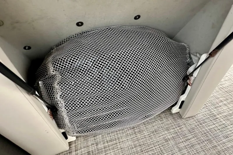 Slide: The Image of Mesh-covered storage compartment in 2023 Harris 230 Cruiser boat interior. - 22