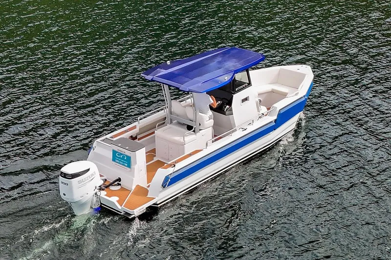 Slide: The Image of 2025 Norseman C280 Center Console boat cruising on water with blue canopy. - 1