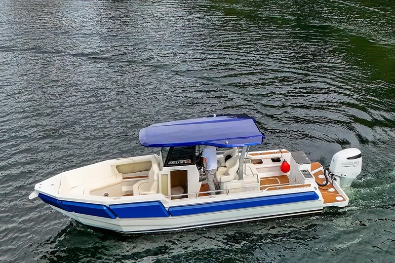 Slide: The Image of 2025 Norseman C280 Center Console boat cruising on water with blue canopy. - 2