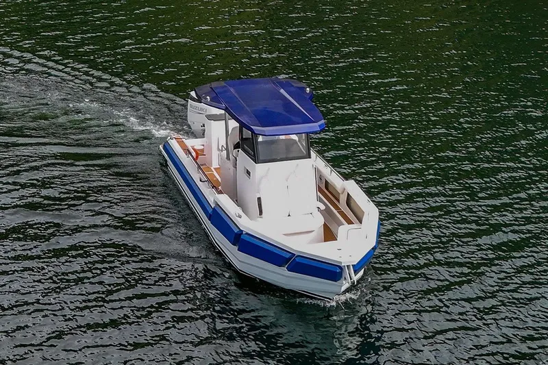 Slide: The Image of 2025 Norseman C280 Center Console boat cruising on water with blue canopy. - 3