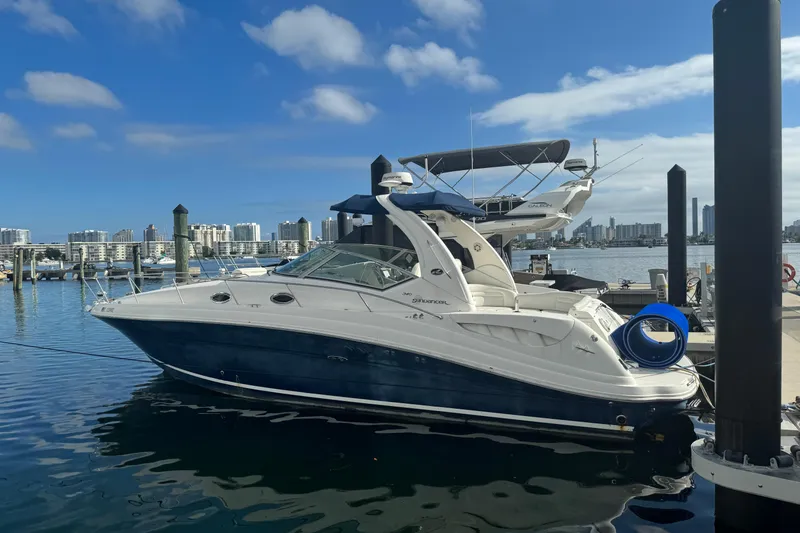 The Image of 2008 Sea Ray 340 Sundancer yacht docked at marina with city skyline backdrop. - 0