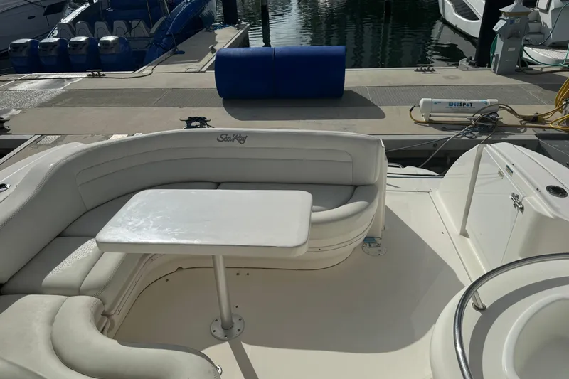 Slide: The Image of 2008 Sea Ray 340 Sundancer boat interior with white seating and table at dock. - 7
