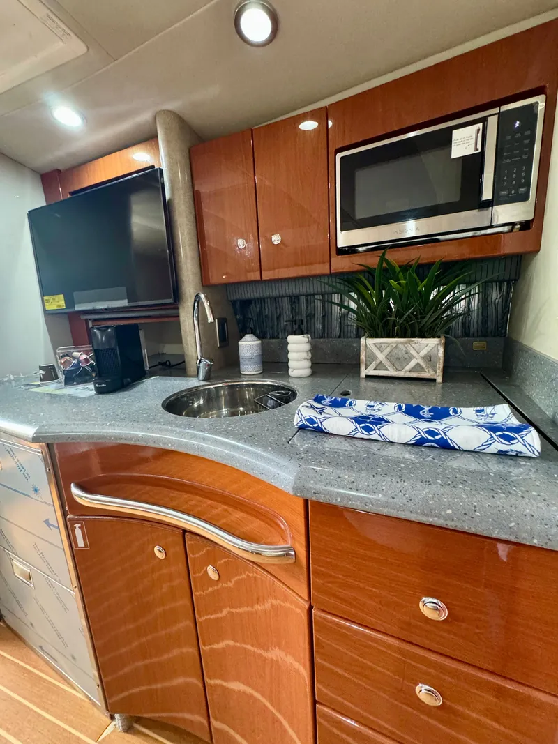 Slide: The Image of 2006 Formula 40pc yacht kitchen with microwave, sink, and wooden cabinetry. - 13