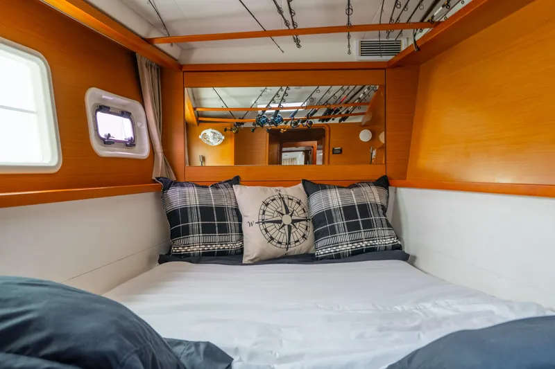 Slide: The Image of Cozy cabin interior of 2013 Lagoon 450 yacht with nautical-themed pillows and wooden accents. - 104