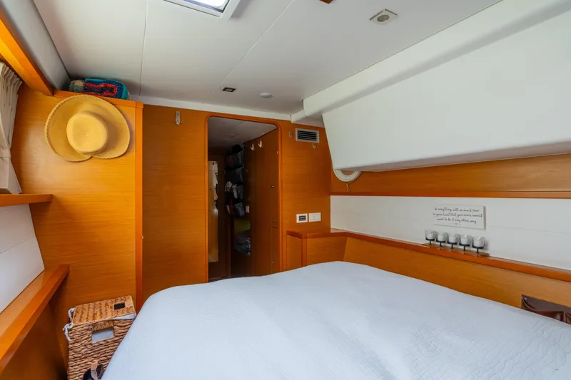 Slide: The Image of Interior of 2013 Lagoon 450 yacht cabin with cozy bed and wooden accents. - 114