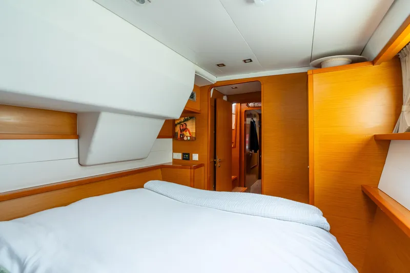 Slide: The Image of Cozy cabin interior of 2013 Lagoon 450 yacht with wooden accents and comfortable bedding. - 119