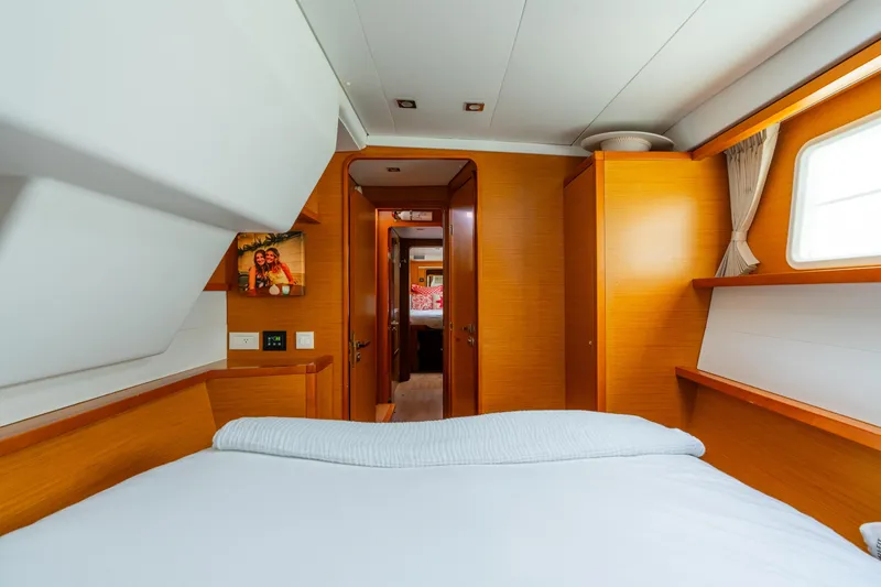Slide: The Image of Interior of 2013 Lagoon 450 yacht cabin with cozy bed and wooden furnishings. - 120