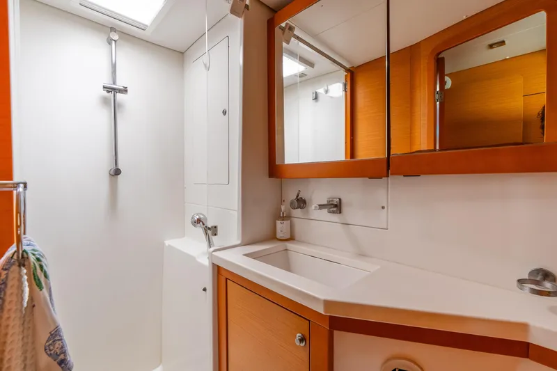 Slide: The Image of Modern bathroom in a 2013 Lagoon 450 yacht, featuring a shower and wooden cabinetry. - 123