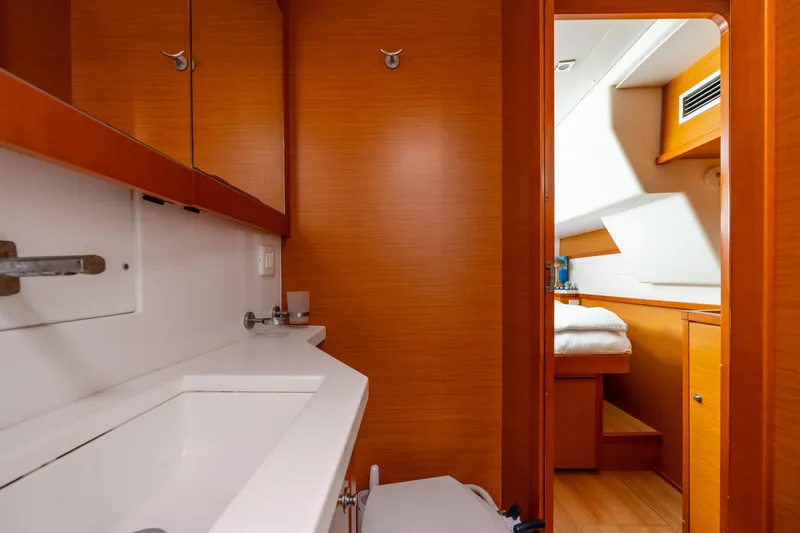 Slide: The Image of Interior of 2013 Lagoon 450 yacht, featuring a wooden bathroom and cozy cabin. - 124