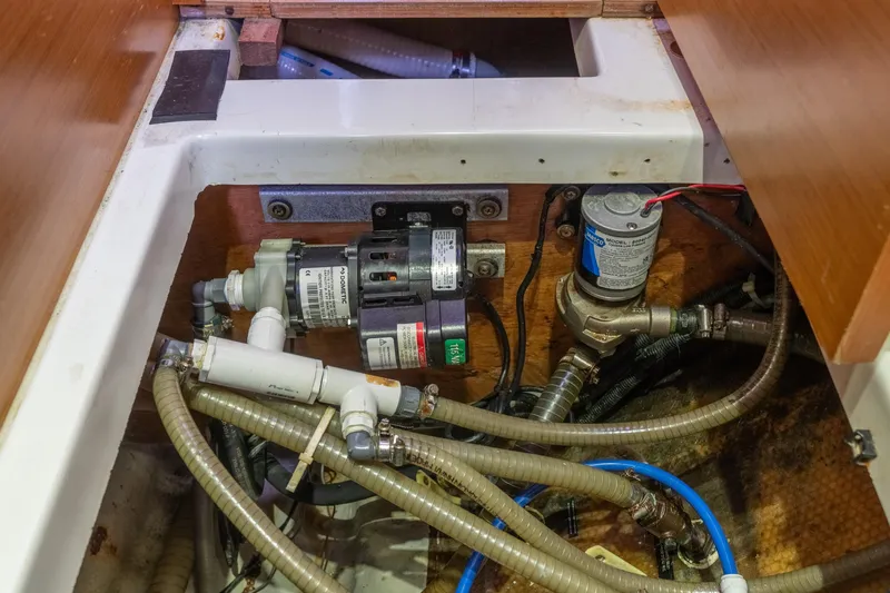 Slide: The Image of Engine compartment of a 2013 Lagoon 450 catamaran, showcasing pumps and hoses. - 131