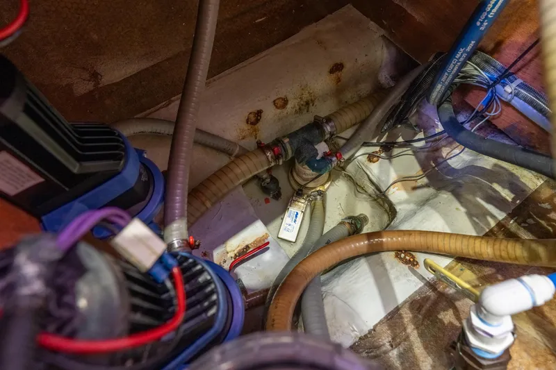 Slide: The Image of Bilge area of a 2013 Lagoon 450 catamaran with visible hoses and wiring. - 132