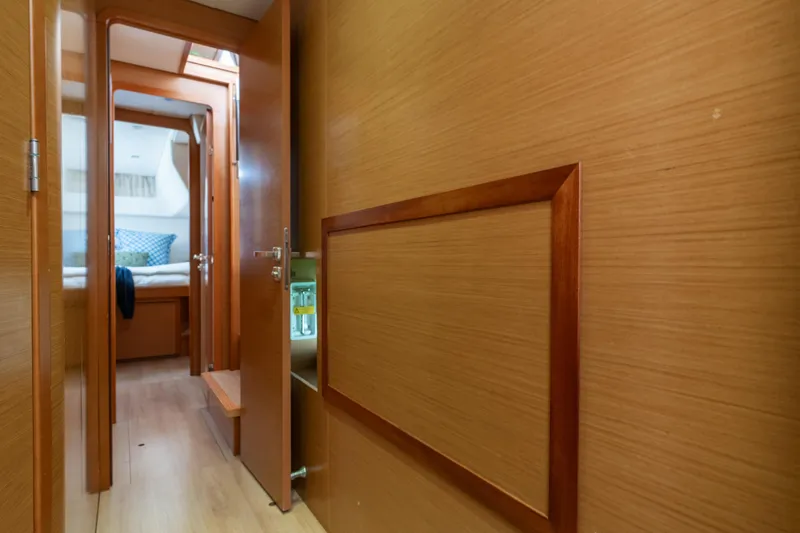Slide: The Image of Interior hallway of 2013 Lagoon 450 yacht, featuring wooden paneling and cozy cabin view. - 134