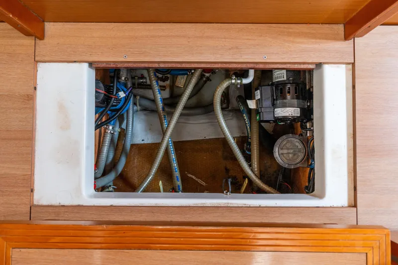 Slide: The Image of Engine compartment of a 2013 Lagoon 450 catamaran, showing hoses and mechanical components. - 139