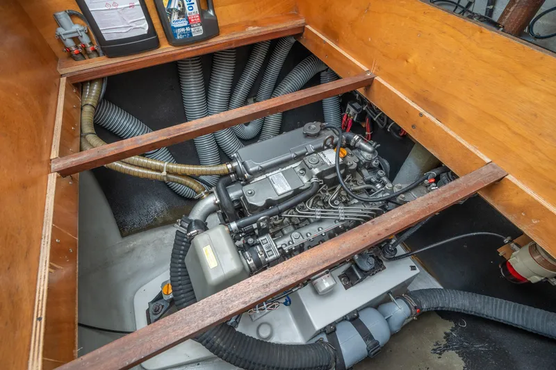 Slide: The Image of Engine compartment of a 2013 Lagoon 450 catamaran, showcasing mechanical components and hoses. - 146