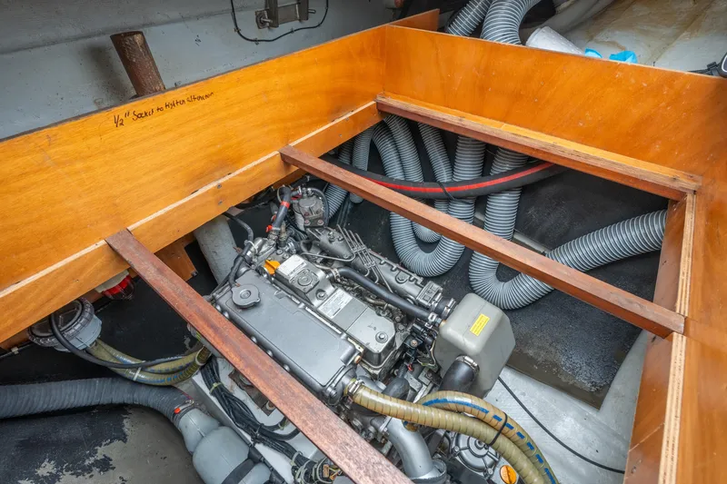 Slide: The Image of Engine compartment of a 2013 Lagoon 450 catamaran, showcasing mechanical components and hoses. - 148