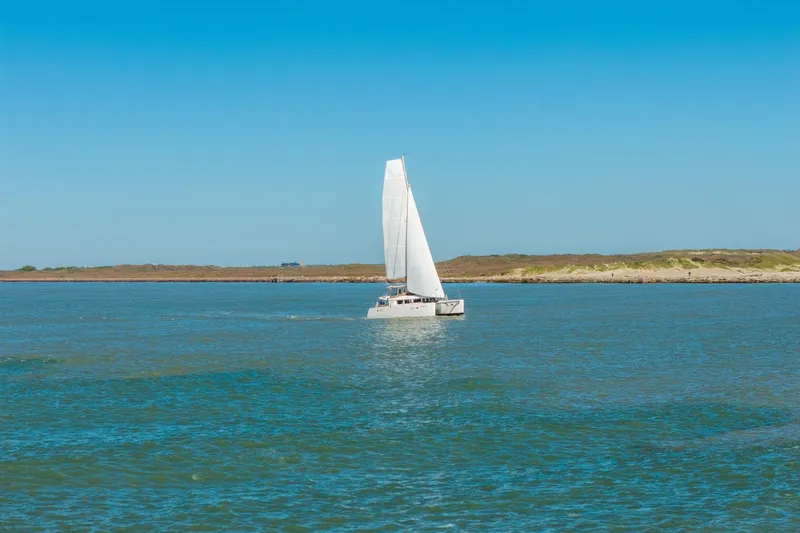 Slide: The Image of Sailing Lagoon 450 catamaran from 2013 on open water under clear blue sky. - 150