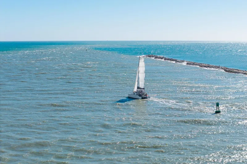 Slide: The Image of Sailing Lagoon 450 catamaran on open sea, 2013 model, under clear blue sky. - 154