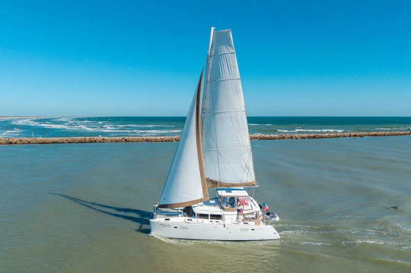 Slide: The Image of 2013 Lagoon 450 catamaran sailing on open sea under clear blue sky. - 163