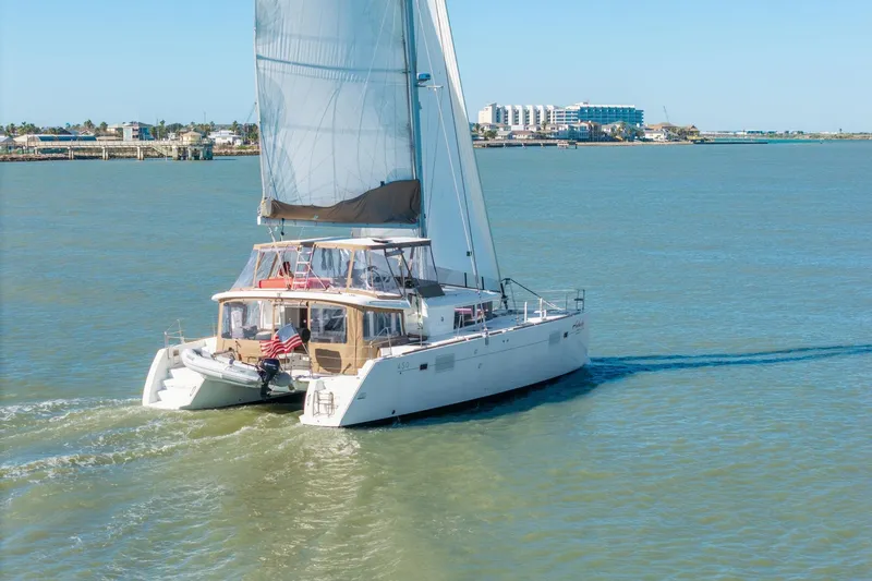 Slide: The Image of 2013 Lagoon 450 catamaran sailing on calm waters near coastal buildings. - 164