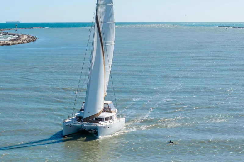 Slide: The Image of Sailing catamaran Lagoon 450, 2013 model, navigating open waters with full sails. - 166