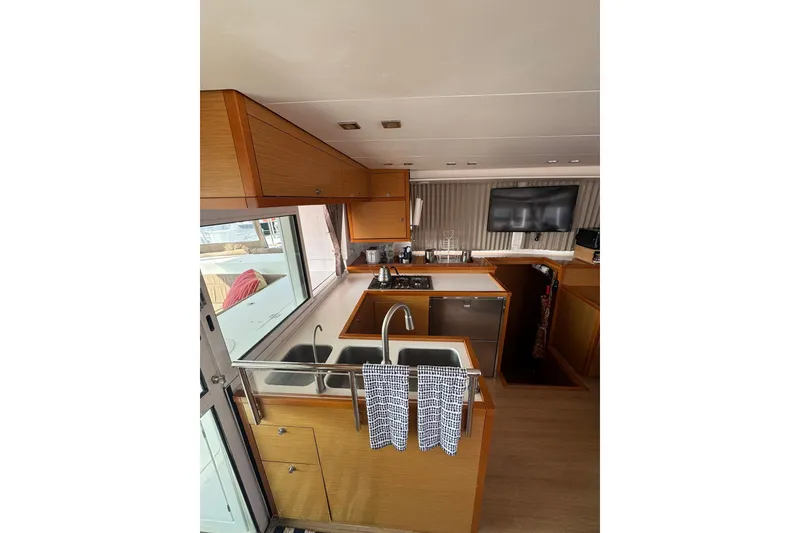 Slide: The Image of Interior view of 2013 Lagoon 450 catamaran with helm, seating, and ocean backdrop. - 25