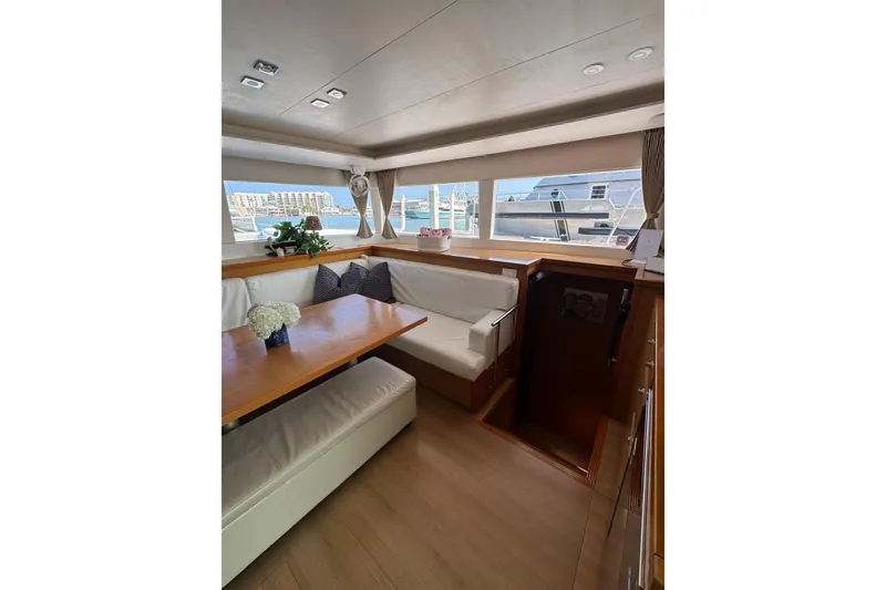 Slide: The Image of Interior view of 2013 Lagoon 450 catamaran cockpit with striped seating and ocean backdrop. - 29