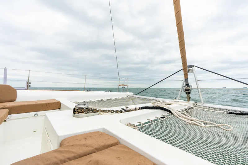 Slide: The Image of 2013 Lagoon 450 catamaran deck with netting, ocean view, and cloudy sky. - 42