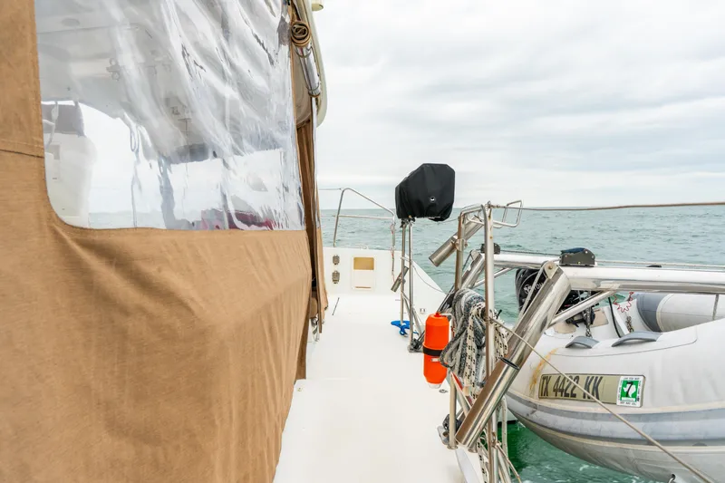 Slide: The Image of 2013 Lagoon 450 catamaran deck with dinghy and ocean view. - 49