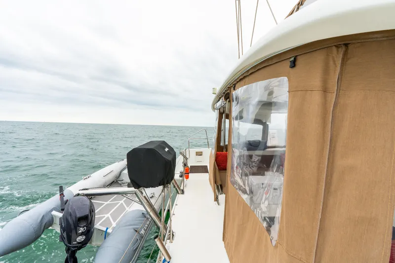 Slide: The Image of 2013 Lagoon 450 catamaran with dinghy on open sea, overcast sky. - 50