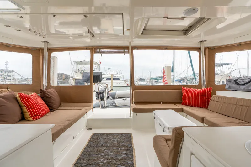 Slide: The Image of Interior of 2013 Lagoon 450 catamaran with cozy seating and marina view. - 56