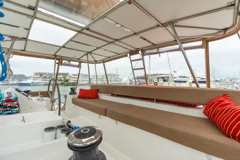 Slide: The Image of Interior view of 2013 Lagoon 450 catamaran with seating and marina backdrop. - 60