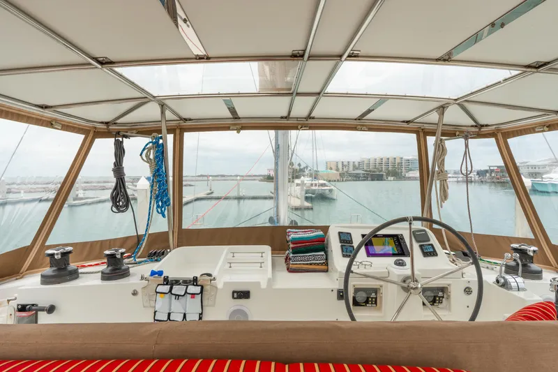 Slide: The Image of Cockpit view of 2013 Lagoon 450 catamaran with marina backdrop. - 67