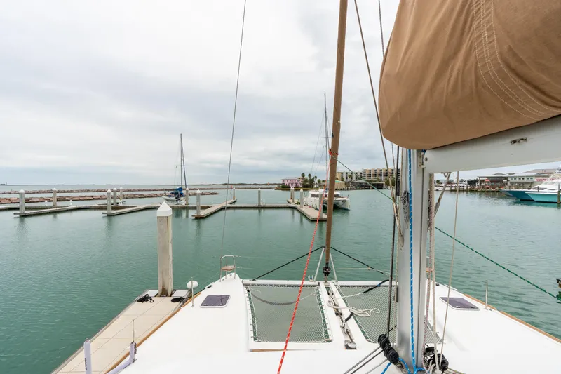 Slide: The Image of Lagoon 450 catamaran docked in a marina, 2013 model, with calm waters and cloudy sky. - 70
