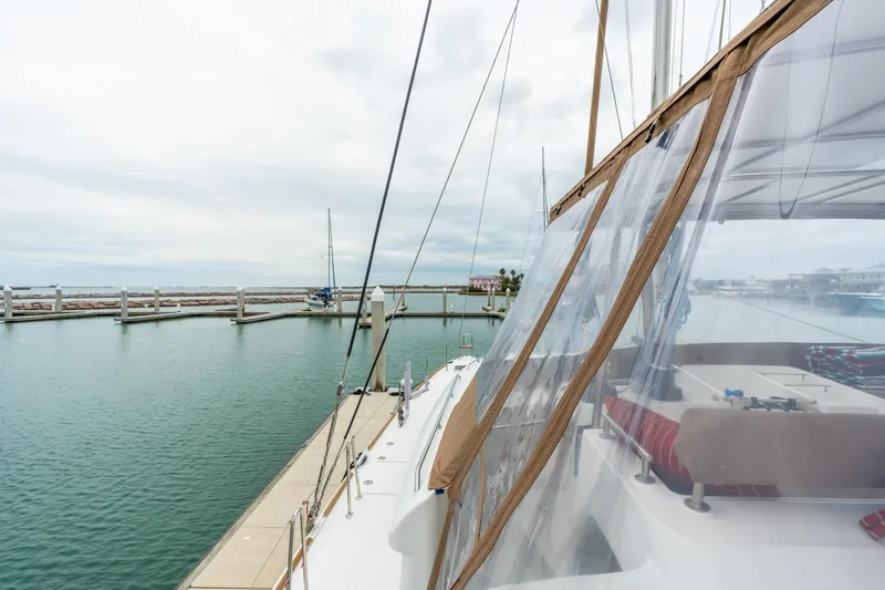Slide: The Image of Lagoon 450 catamaran docked at marina, showcasing deck and clear canopy, 2013 model. - 73