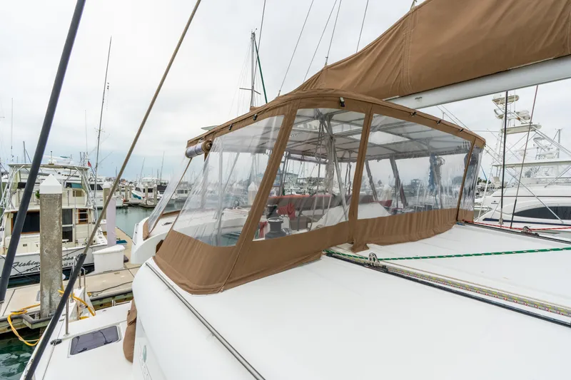 Slide: The Image of 2013 Lagoon 450 catamaran docked at marina with brown canopy enclosure. - 75