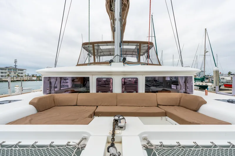 Slide: The Image of 2013 Lagoon 450 catamaran with spacious outdoor seating at a marina. - 79