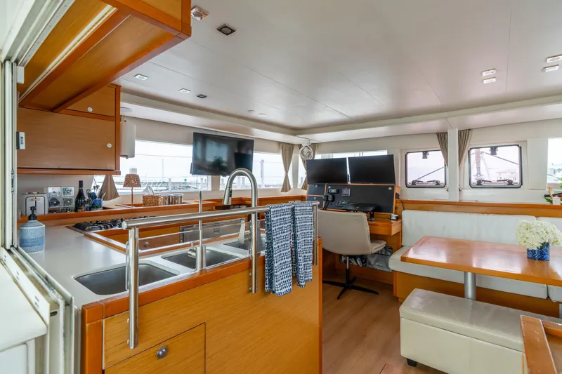 Slide: The Image of Interior of 2013 Lagoon 450 catamaran with modern kitchen, dining area, and navigation station. - 93