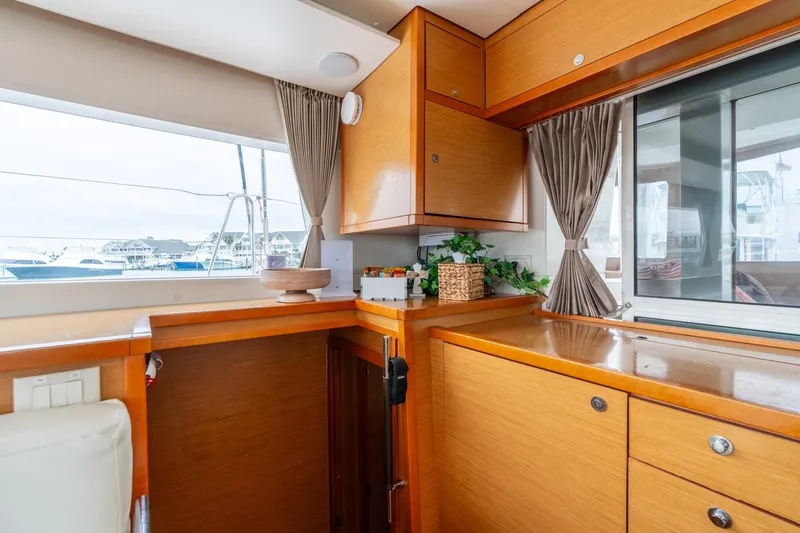 Slide: The Image of Interior of 2013 Lagoon 450 yacht with wooden cabinetry and marina view. - 95