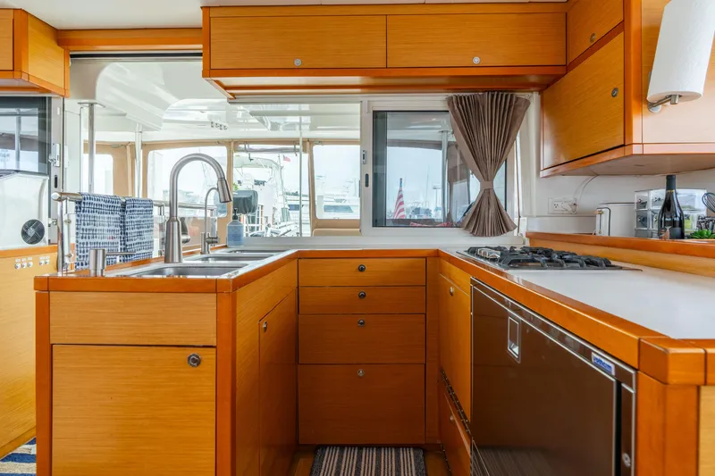 Slide: The Image of Luxurious kitchen interior of 2013 Lagoon 450 yacht with modern amenities and wooden cabinetry. - 97