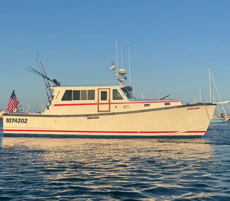 The Image of 1998 Wilbur 38 Downeast boat on calm water, displaying American flag. - 0
