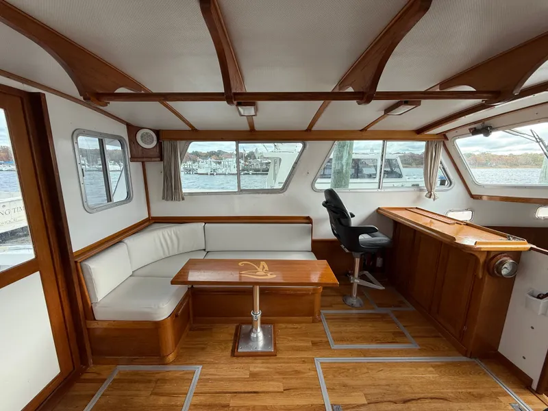 Slide: The Image of Interior of 1998 Wilbur 38 Downeast boat with seating and helm, featuring wood accents. - 10
