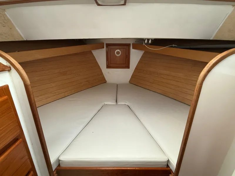 Slide: The Image of 1998 Wilbur 38 Downeast boat interior with wooden paneling and white cushions. - 18
