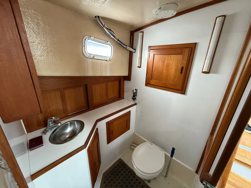 Slide: The Image of 1998 Wilbur 38 Downeast boat bathroom with wooden cabinets and stainless steel sink. - 22